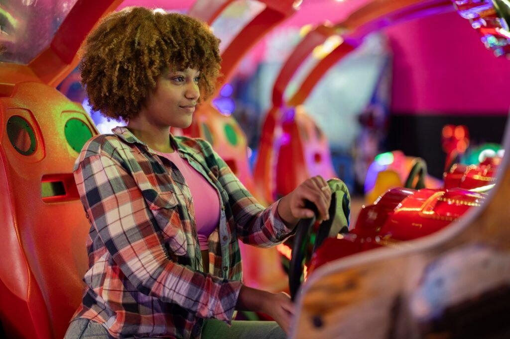 Curly-Haired Young Woman Enjoying a Space-Themed Arcade Game